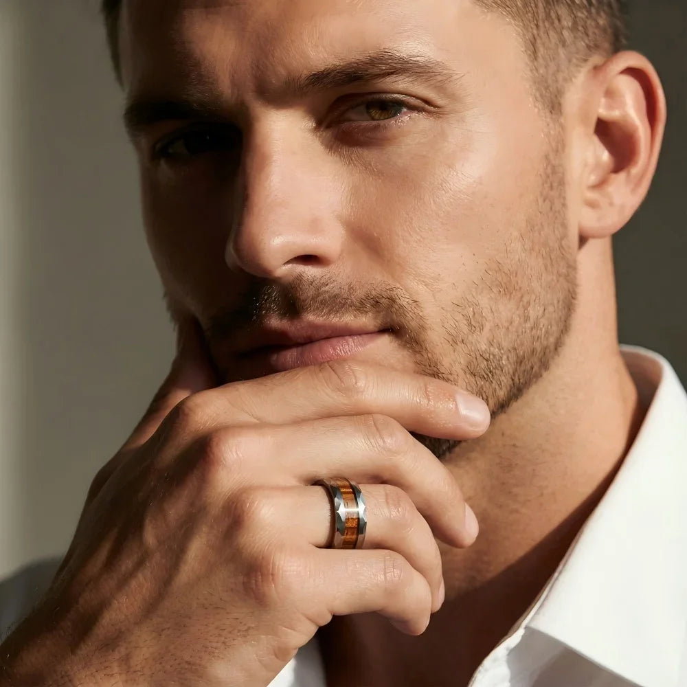 Man's hand wearing The Heritage Cask Aerospace-grade Tungsten and whiskey barrel wood ring with fingers resting thoughtfully against the chin in a focused pose.