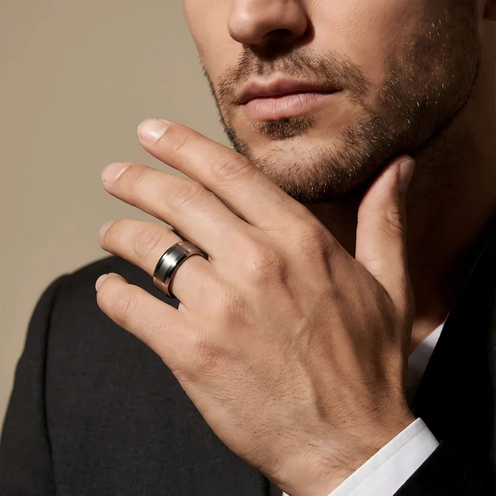 Man's hand wearing The Obelisk Aerospace-grade Tungsten ring, with fingers resting thoughtfully against the jawline under focused studio lighting.