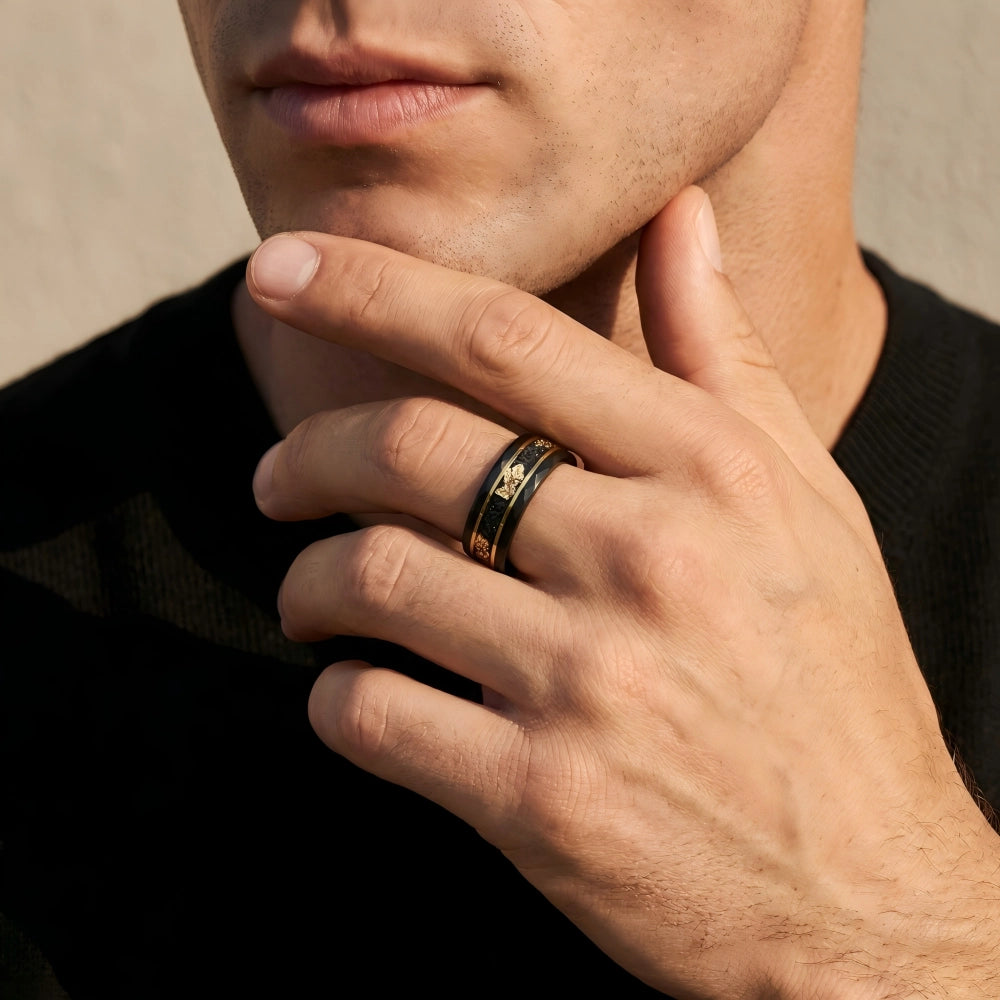 Man's hand wearing The Void Fragment Black Aerospace-grade Tungsten ring, with fingers resting thoughtfully against the jawline in a structured, focused setting.