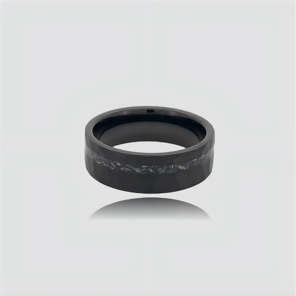 The Midnight Rift Precision-engineered ring featuring hammered Black Aerospace-grade Tungsten and a dark crystalline meteorite inlay.