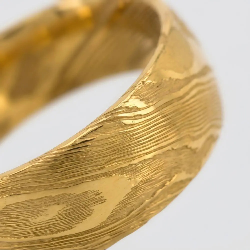 Macro detail of central distressed texture and intricate stratigraphic pattern on The Altar Strata showcasing Forged Damascus steel with 18K Gold PVD coating.