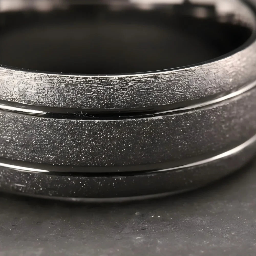 Macro detail of raw granular sandblasted texture and precision-milled polished grooves on The Argent Monolith showcasing silver-tone Aerospace-grade Tungsten.
