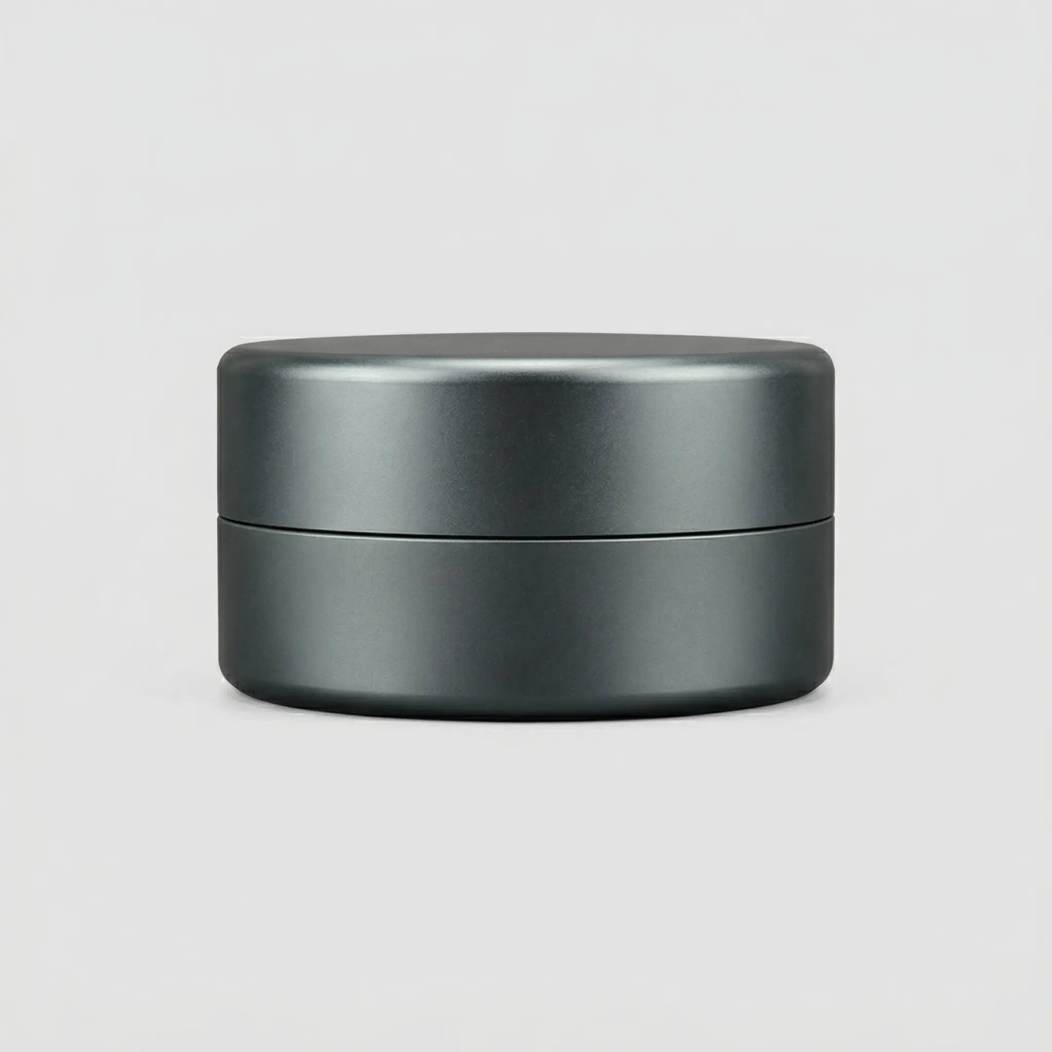 Matte metallic round jewelry box with smooth structural design on a light background