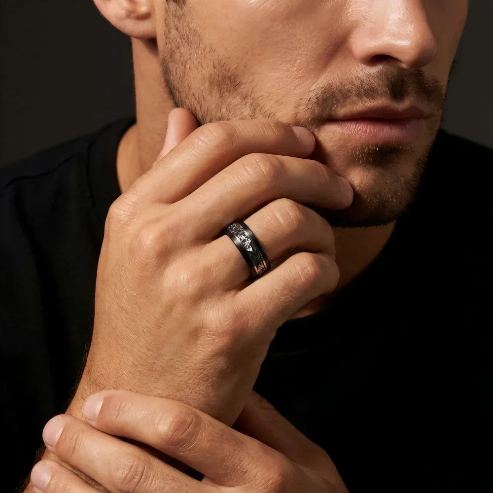 Man's hand wearing The Stellar Rift Black Aerospace-grade Tungsten ring, with fingers resting thoughtfully against the jawline under focused studio lighting.