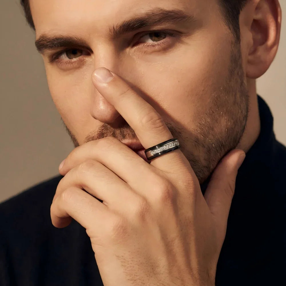 Man's hand wearing The Obsidian Prism black ceramic ring, with a finger touching the bridge of the nose in a focused, contemplative pose.