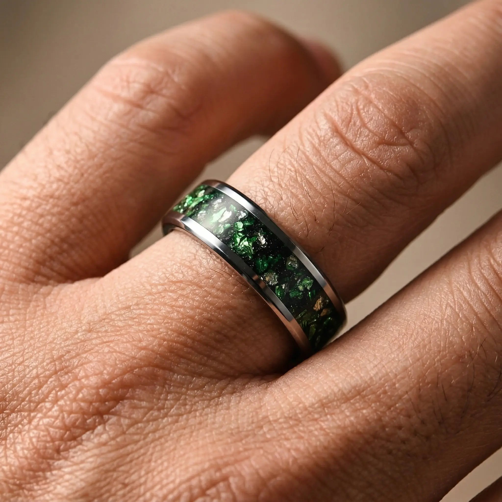 Man's hand wearing The Verdant Pulse Aerospace-grade Tungsten ring resting naturally under focused studio lighting.